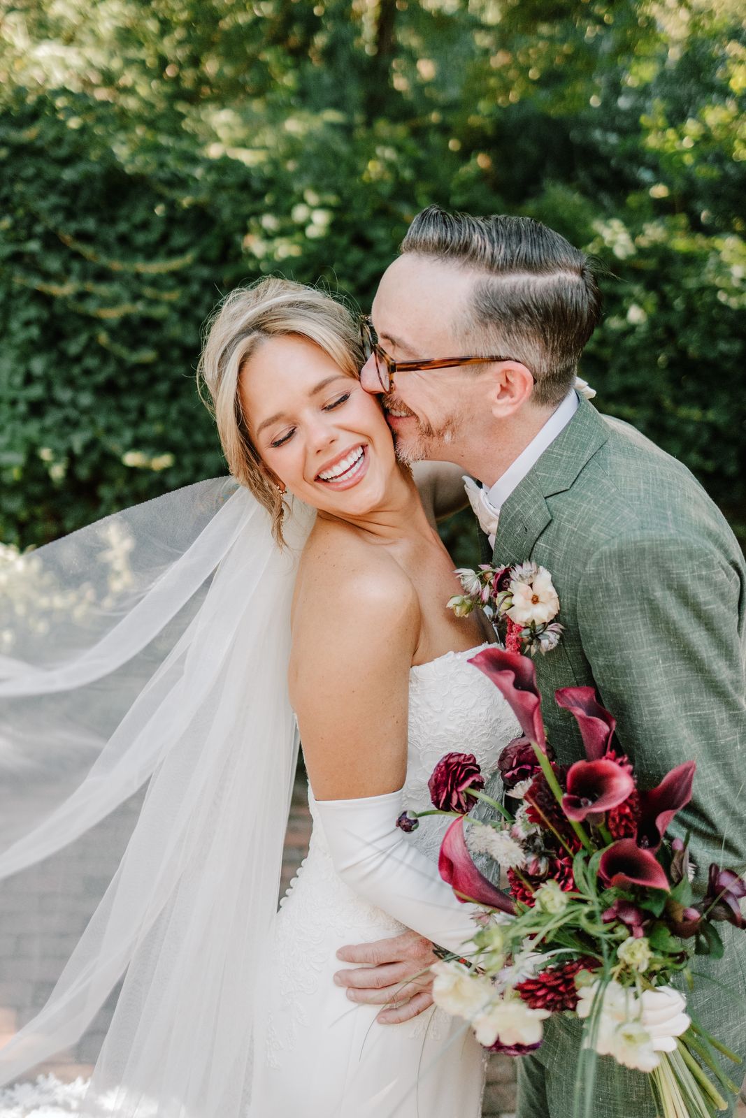 MacKenzie laughing as her husband kisses her cheek